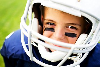 young boy of 10 years old smiling from a football helmet provided by HAVlife